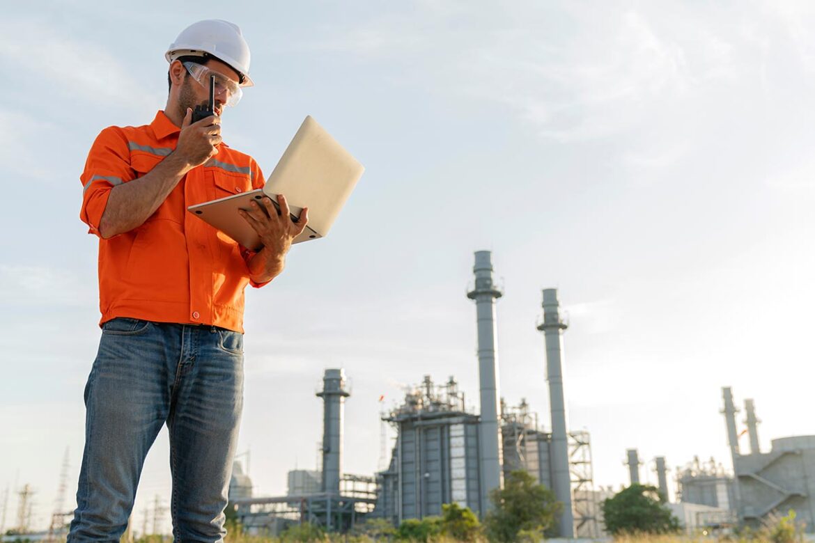 engineer technician Industrial workers wearing safty uniform with walkie-talkie and laptop working inspection in a power plant background